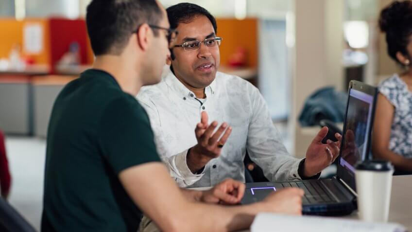 Two men can be seen mid-discussion during a scientific seminar.