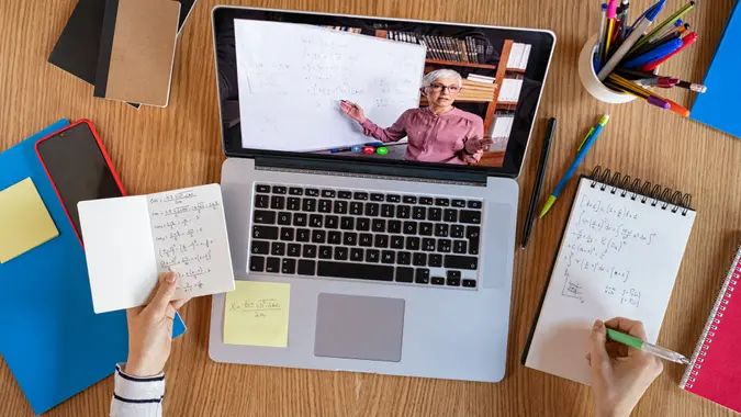 High angle view of video conference with teacher on laptop at home.