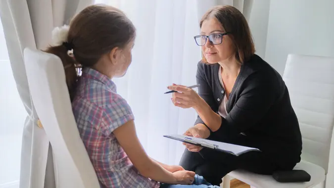 Woman social worker talking to girl.