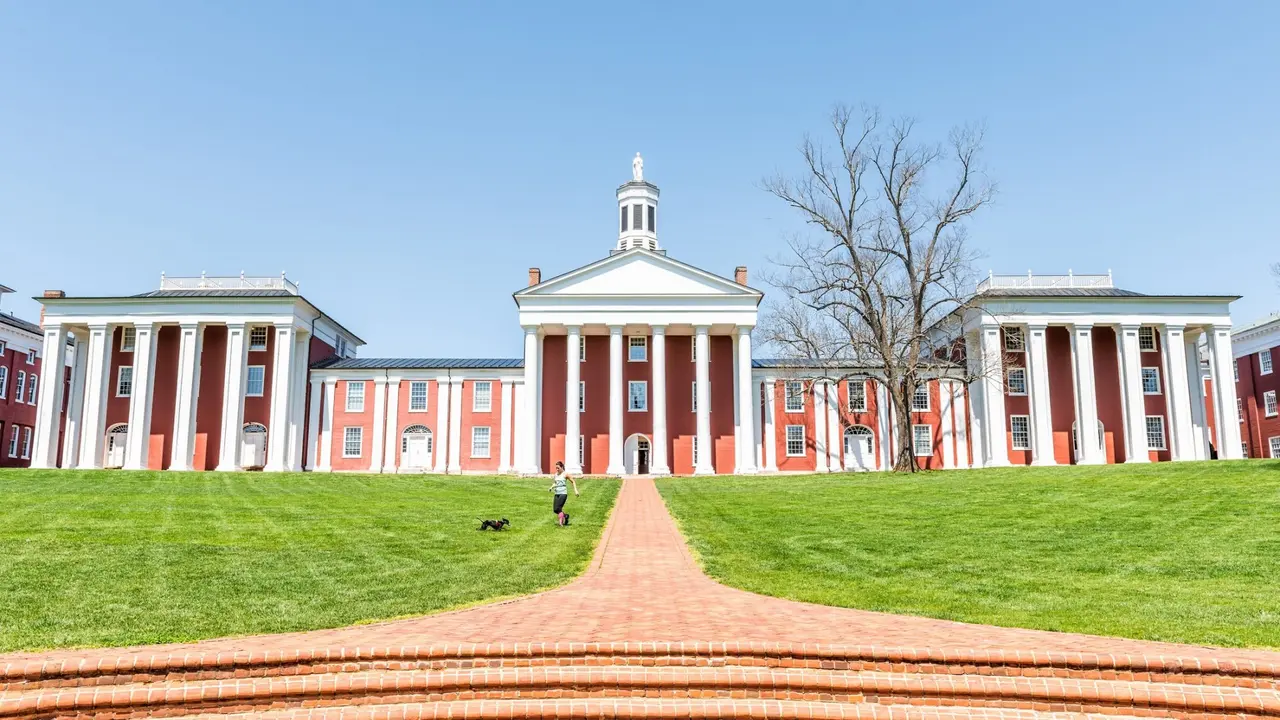 Lexington, USA - April 18, 2018: Washington and Lee University hall in Virginia exterior facade during sunny day with woman walking down, exterior brick architecture.