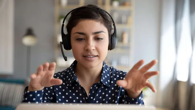 Indian young business woman student teacher tutor wear wireless headset video conference calling on laptop computer talk by webcam learn teach in online chat, distance webinar online teaching concept.