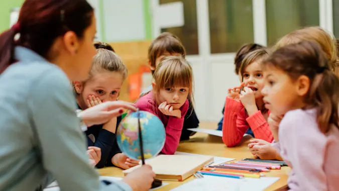 Preschool teacher teaching her children about geography.