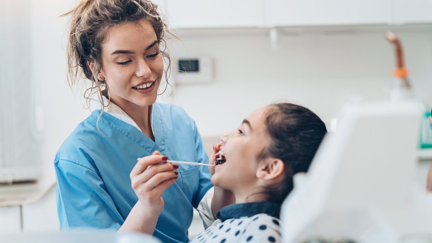 Dentist and a girl patient in the dentist's office.