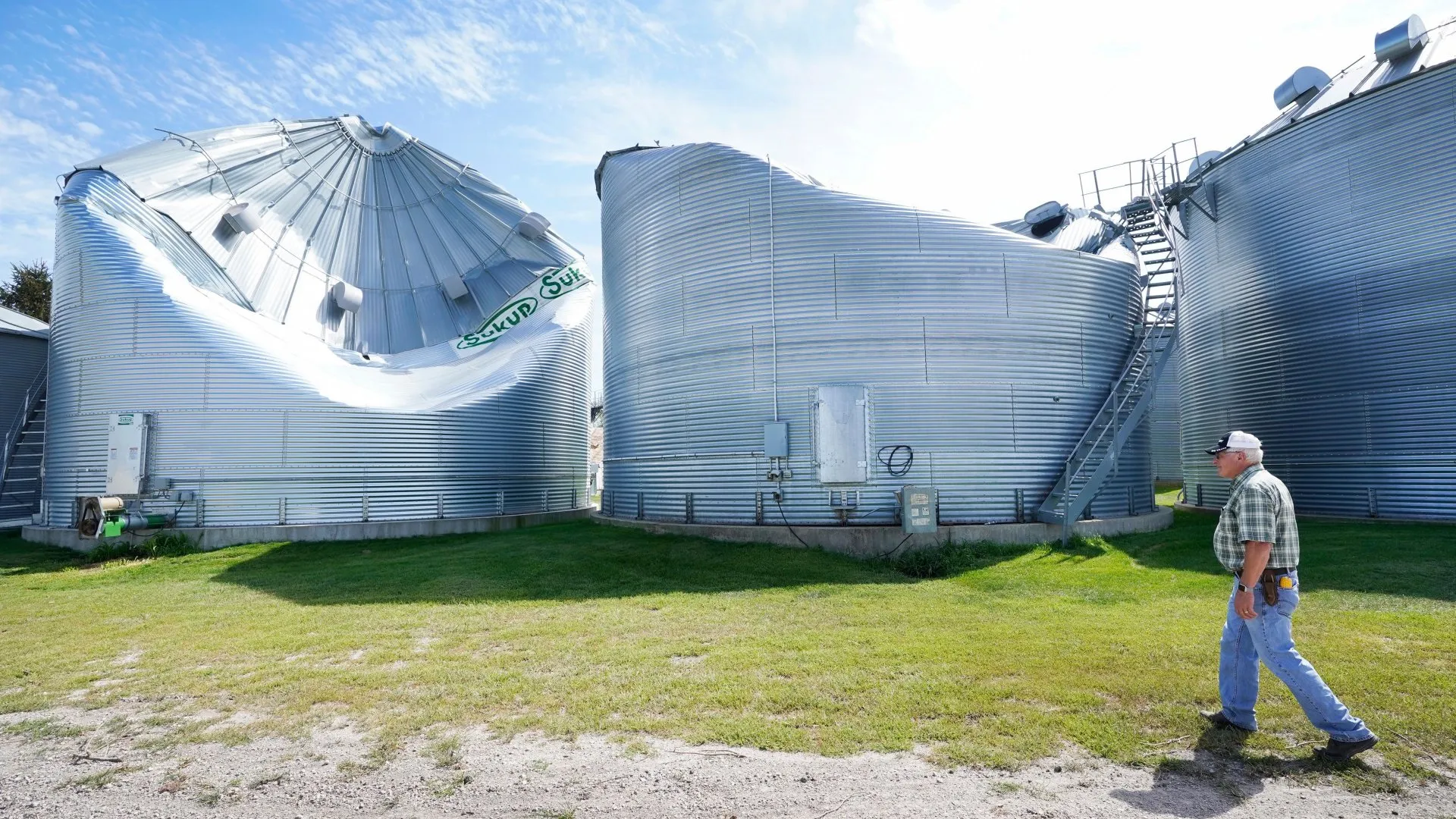 本月早些时候，爱荷华州伍德沃德附近，罗德·皮尔斯(Rod Pierce)看着他农场上的谷物干燥箱，这些干燥箱在德雷波中被损坏。