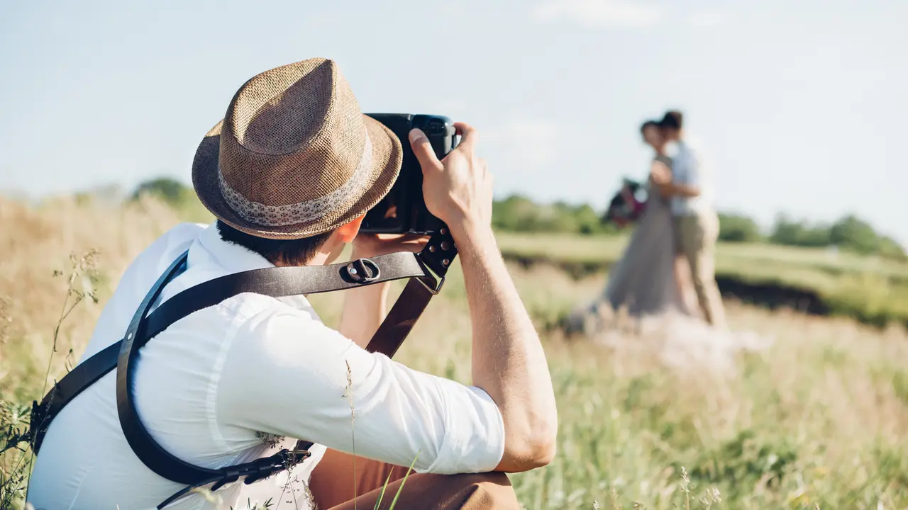 wedding photographer takes pictures of bride and groom in nature in summer, fine art photo.