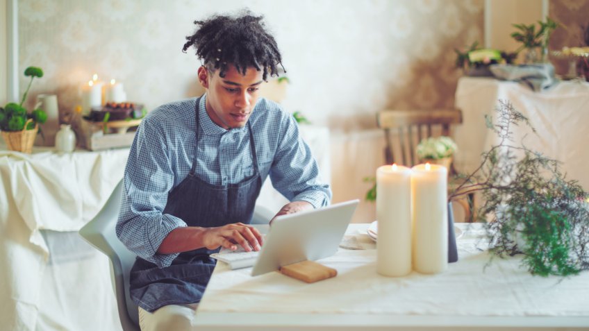 Hipster entrepreneur is communicating with his clients online.