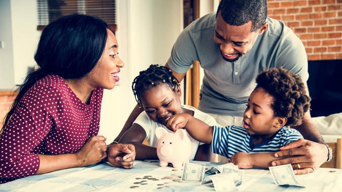 Family putting money in a piggy bank