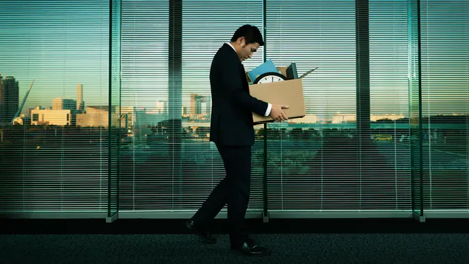 Subject: A Japanese business office worker leaving his job with all his belonging in a layoff and economic recession.