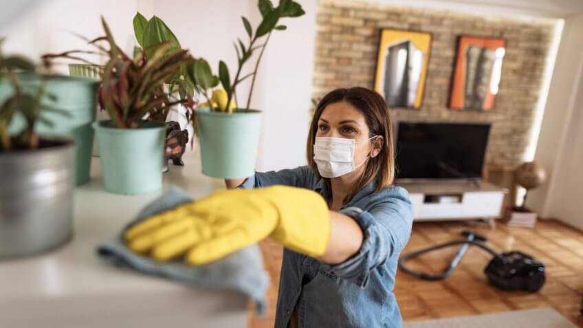 Woman working at home, cleaning the floors, washing the laundry and cleaning up the mess in the closet during quarantine.