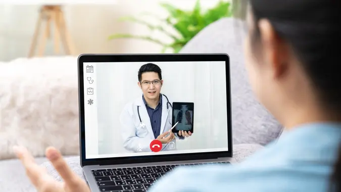 Asian chinese doctor video conference call online talking for follow up remotely with medical coronavirus result at home.