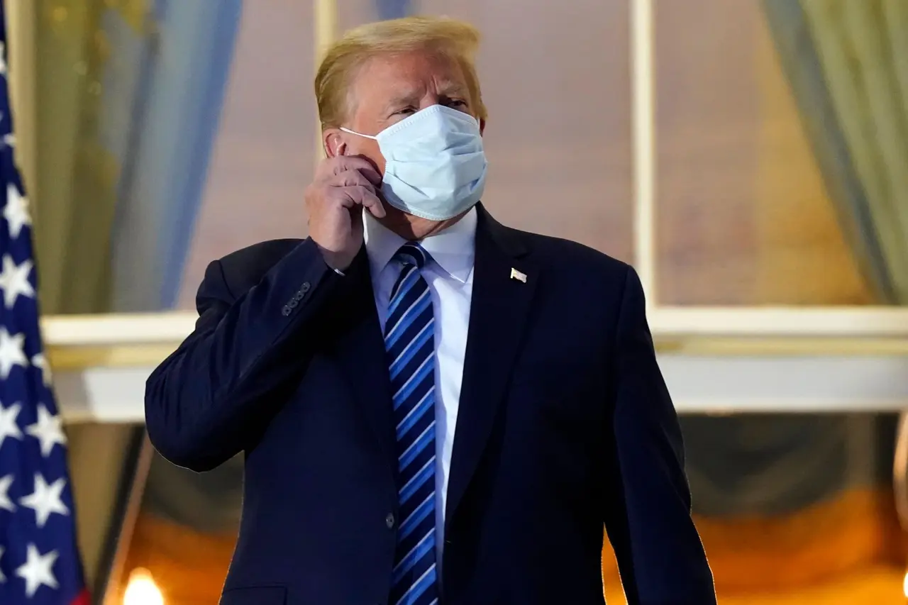 Mandatory Credit: Photo by Alex Brandon/AP/Shutterstock (10911987r)President Donald Trump removes his mask as he stands on the balcony outside of the Blue Room as returns to the White House, in Washington, after leaving Walter Reed National Military Medical Center, in Bethesda, Md.