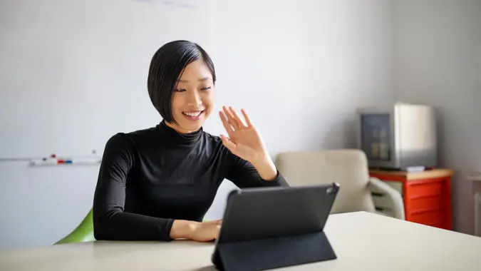 Businesswoman working in office, doing a video call with digital tablet.