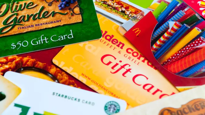 Indialantic, FL, USA - July 29, 2011: A variety of restaurant gift cards on a white background, including Cracker Barrel, McDonald's, Olive Garden, Golden Corral, Subway, Outback, and Starbucks.