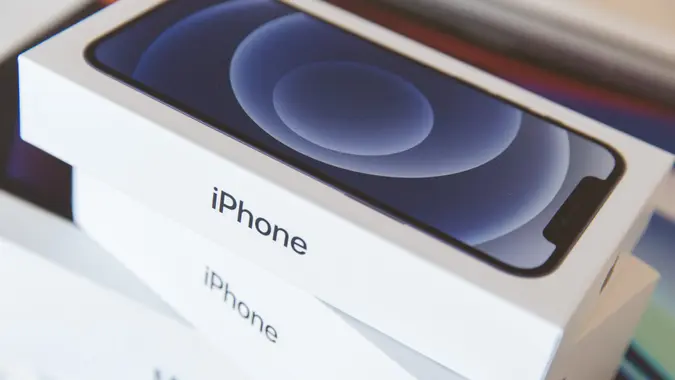 Mandatory Credit: Photo by Stanislav Kogiku/SOPA Images/Shutterstock (10989252n)In this photo illustration two new iPhone 12 packages on top of a MacBook Pro package.
