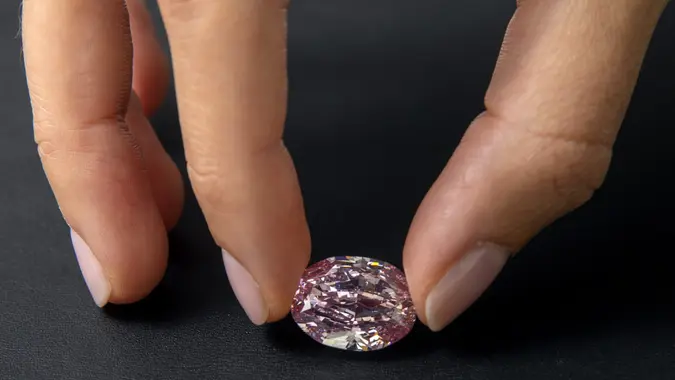 Mandatory Credit: Photo by SALVATORE DI NOLFI/EPA-EFE/Shutterstock (11005295e)A Sotheby's employee poses with 'The Spirit of the Rose' vivid purple-pink diamond weighing 14.