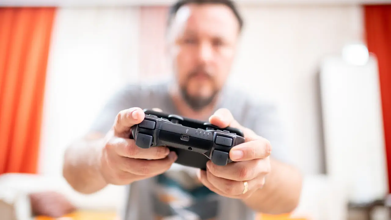 man holding game controller playing video games