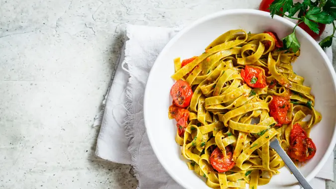 Green spinach pasta with tomatoes and parsley.