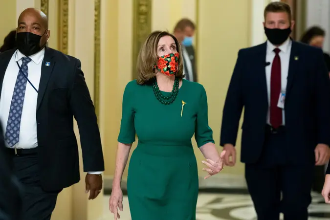 Mandatory Credit: Photo by MICHAEL REYNOLDS/EPA-EFE/Shutterstock (11656667i)US Speaker of the House Nancy Pelosi (C) walks near the House chamber on Capitol Hill in Washington, DC, USA, 21 December 2020.