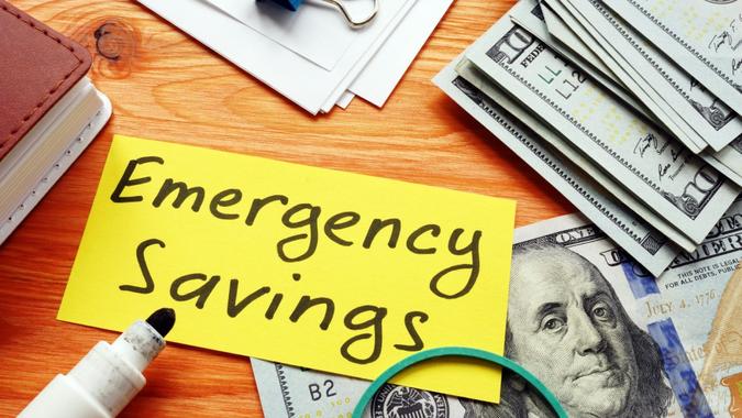 Une note d'épargne d'urgence et une pile d'argent.