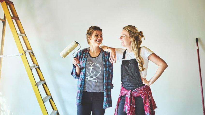 Shot of two young woman busy with renovations at home.