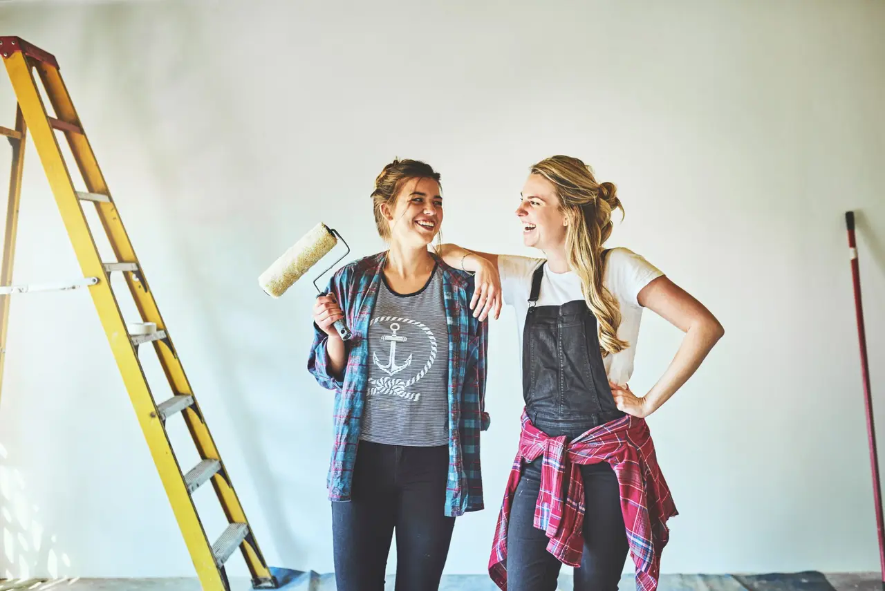 Shot of two young woman busy with renovations at home.