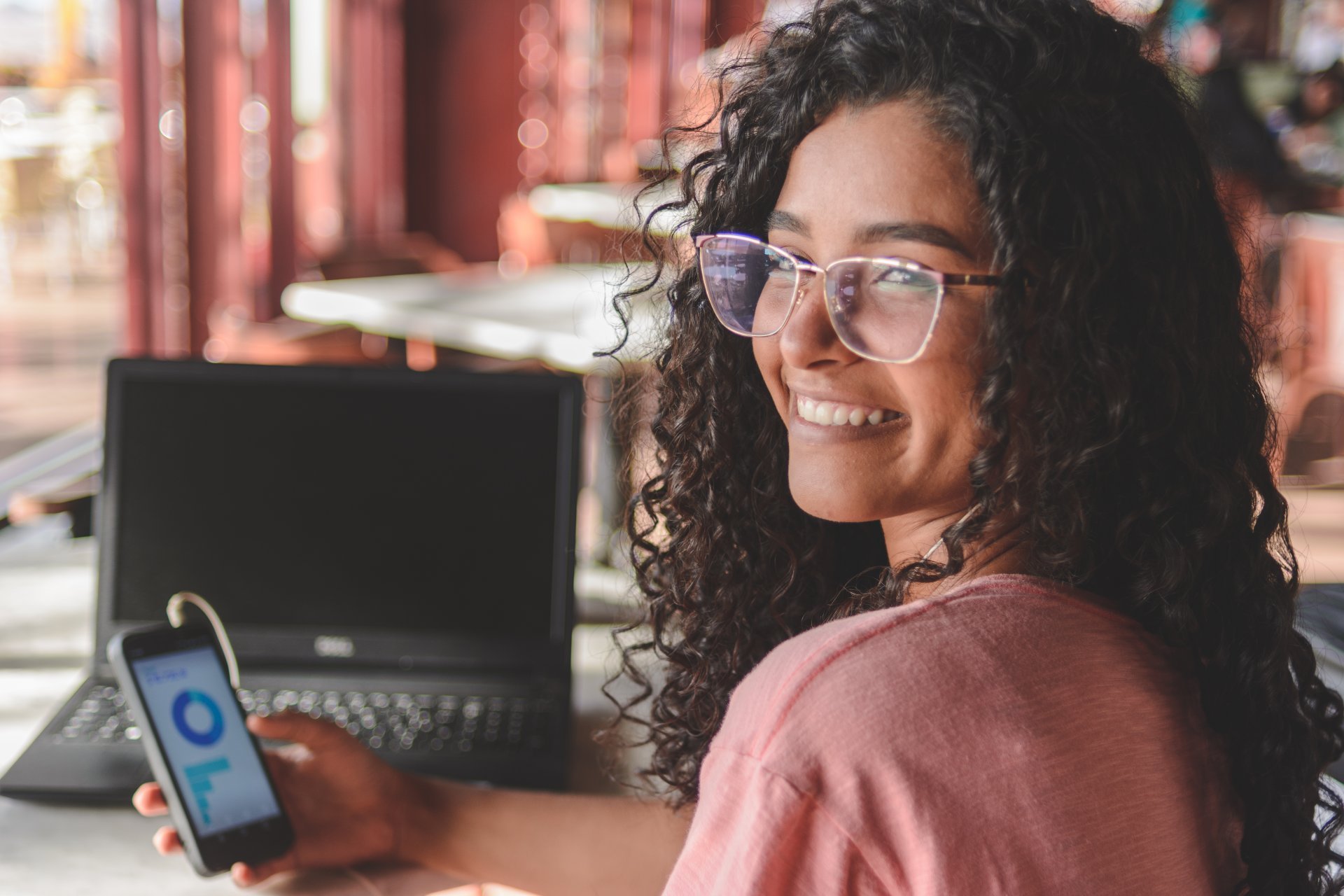 Portrait of young woman using financial app on smartphone.