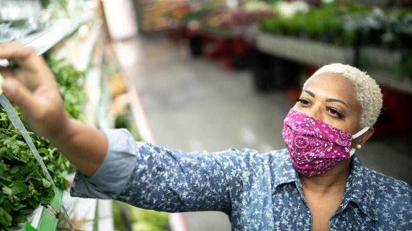 Woman with face mask shopping at supermarket.