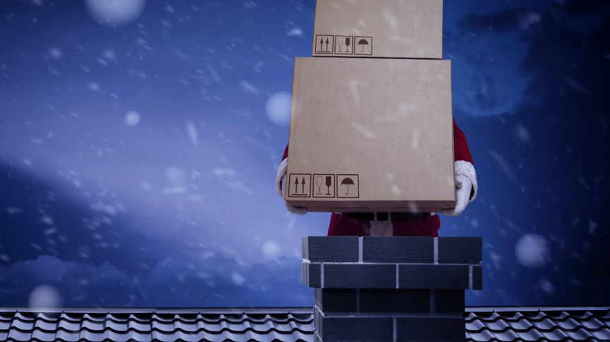 Santa Claus on roof with big boxes.