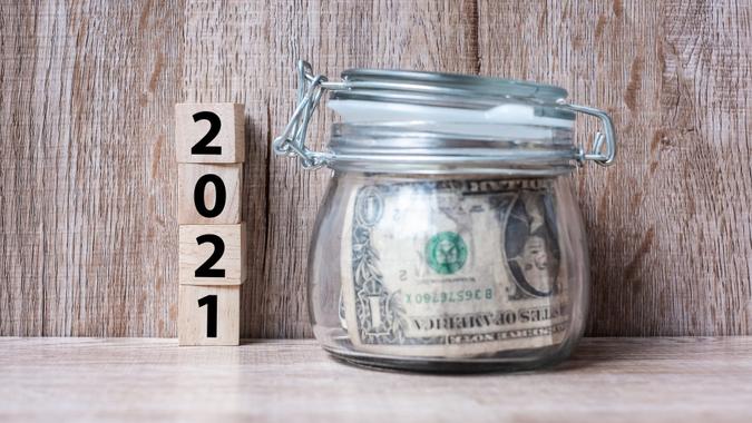 2021 Happy New Year with US dollar money glass American on wood table background.