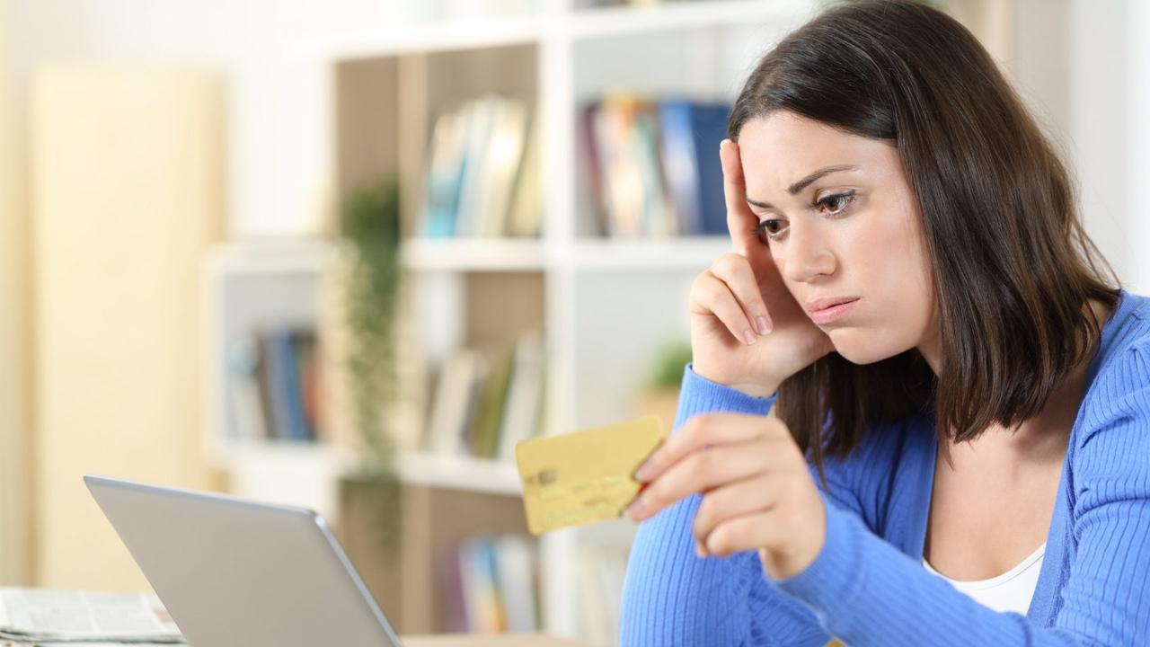 Worried woman having trouble paying with card.