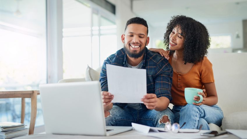 Shot of a happy young couple looking going over their finances at home.