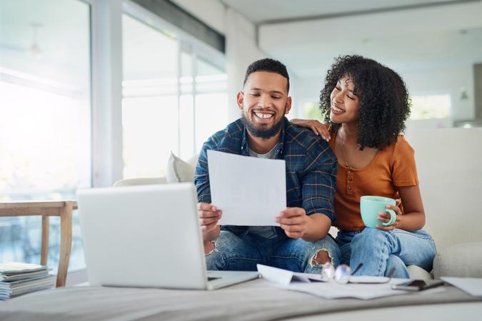 Shot of a happy young couple looking going over their finances at home.