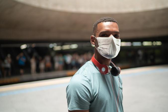 Portrait of a young man using protective mask at metro station.