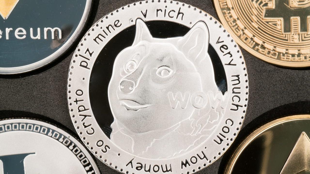 Dogecoin cryptocurrency real silver coin in middle of other crypto.