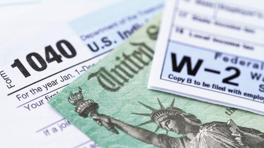 1040 income tax form and w-2 wage statement with a federal Treasury refund check.