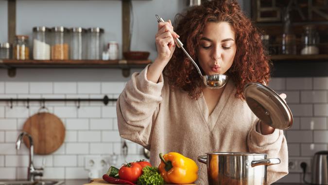 woman eating cooking soup shutterstock_1399381838
