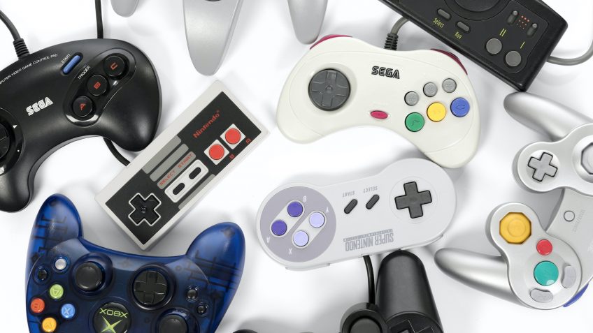Taipei, Taiwan - February 19, 2018: A collection of retro video game controllers shot from above on a white background.