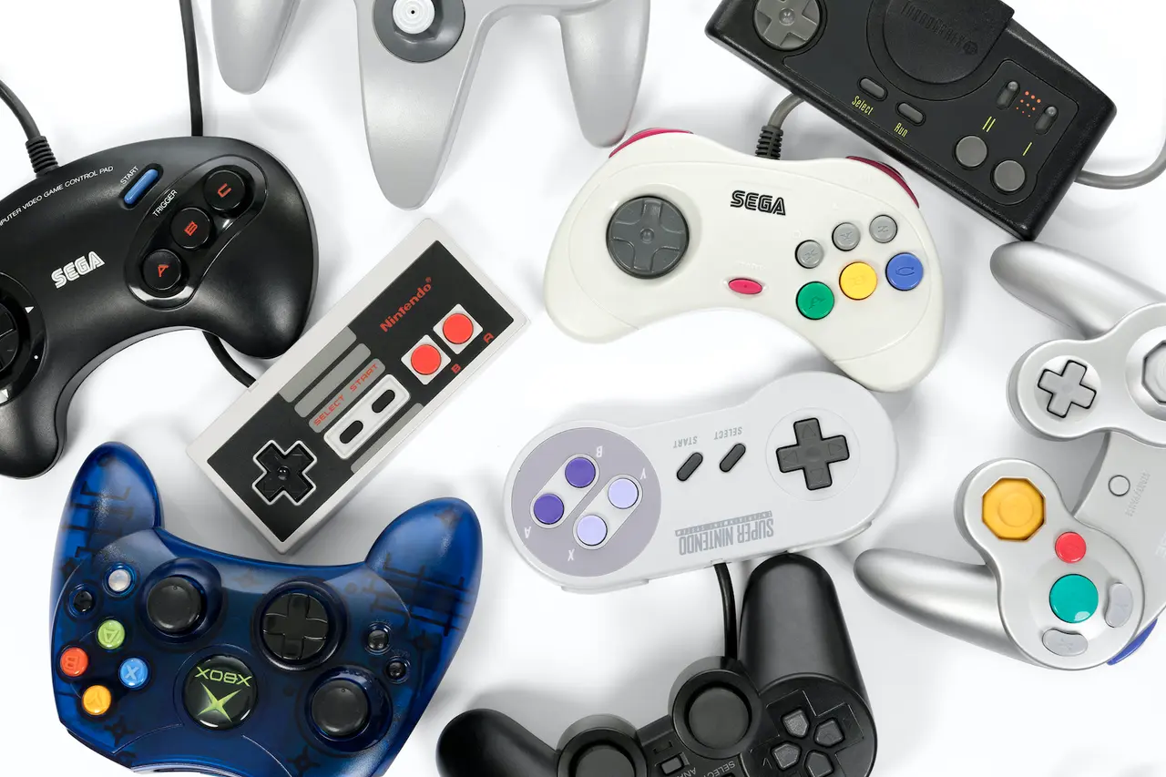 Taipei, Taiwan - February 19, 2018: A collection of retro video game controllers shot from above on a white background.