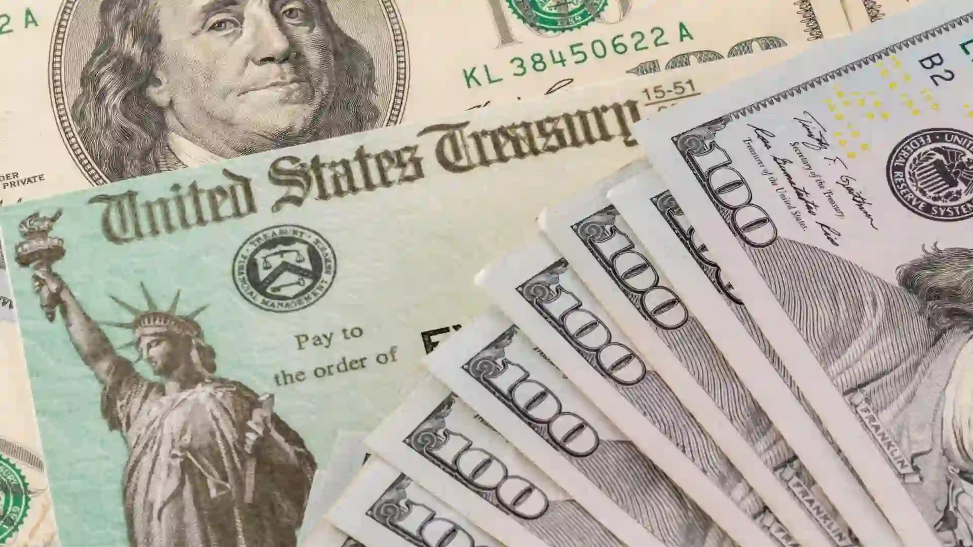 Stack of 100 dollar bills with illustrative coronavirus stimulus payment check to show the virus stimulus payment to Americans.