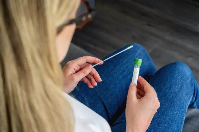 Young woman holds a swab and medical tube for the coronavirus / covid19 home test.
