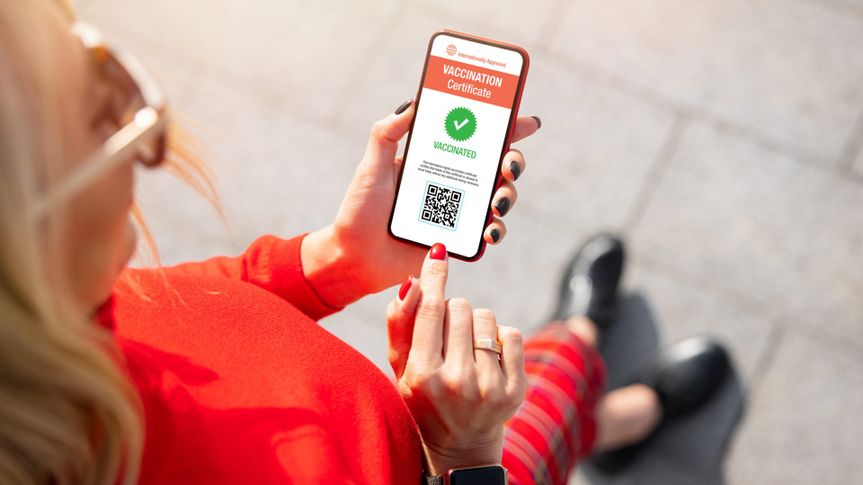 Woman holding mobile phone with valid digital vaccination certificate.