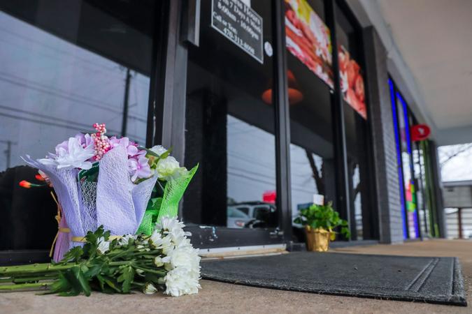 Mandatory Credit: Photo by ERIK S LESSER/EPA-EFE/Shutterstock (11803941e)Flowers left by well-wishers sit at the entrance to Young's Asian Massage spa in Acworth, Georgia, USA, 17 March 2021.