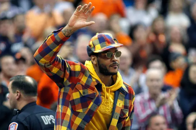 Mandatory Credit: Photo by Nick Lisi/AP/Shutterstock (10468138d)Former Syracuse basketball great Carmelo Anthony waves to the crowd during the first half of an NCAA college basketball game against Virginia in Syracuse, N.