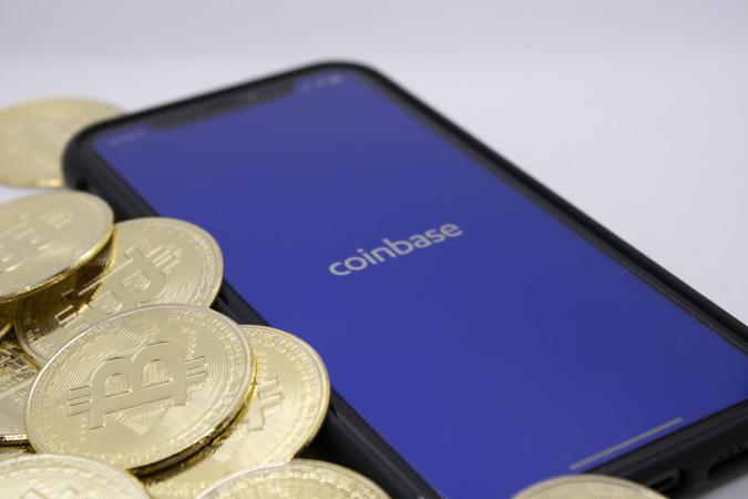 Bitcoins placed next to the Coinbase app on an iPhone, illustrating one of the largest Bitcoin providers, photographed in Cologne, Germany, on April 14, 2021.
