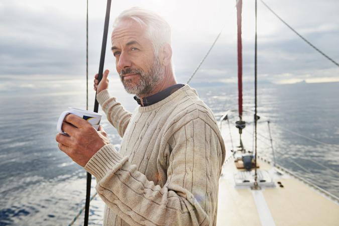 Shot of a mature man on his sailboat drinking a cup of coffee.