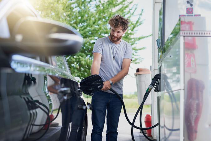 Cropped shot of a handsome young man refuelling his car at a gas station.