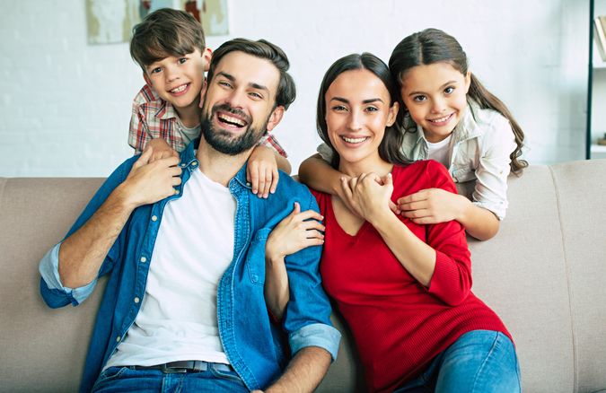Young happy family relax together at home smiling and hugging.