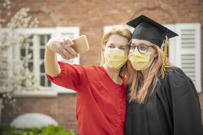 mother and daughter take a selfie in their fac masks for her 2020 graduation.