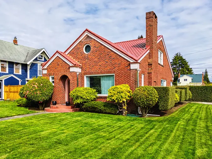Photo of a small American red brick home on a sunny day.