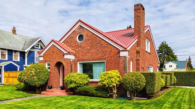 Photo of a small American red brick home on a sunny day.